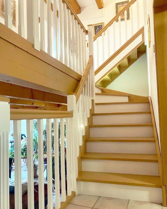 Rénovation d’un escalier en bois avec garde-corps blanc et finition moderne – Travaux réalisés par AK Rénovation dans le Pays de Gex